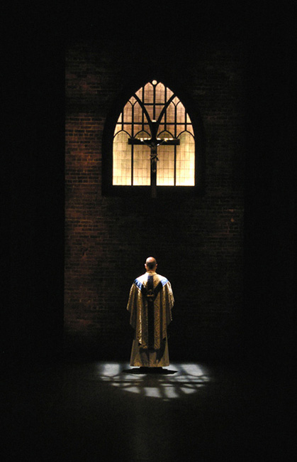 Father Flynn contemplating beneath the church window in DOUBT at Portland Stage Company 