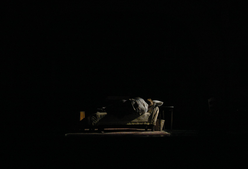 Tom rolls over in bed during scene transition to morning--Theater at Monmouth's GLASS MENAGERIE